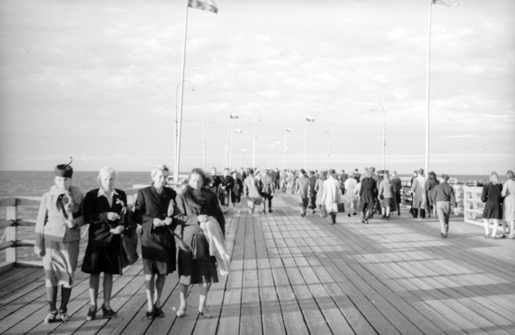 Archiwalne zdjęcie przedstawiające tłumy na molo w popularnym kurorcie nad morzem - Sopocie