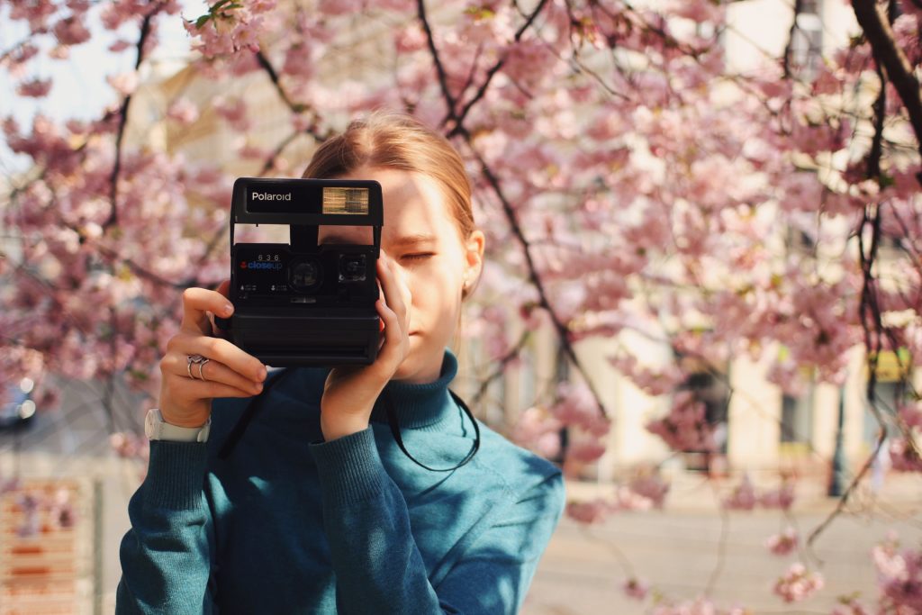 Dziewczyna fotografująca rośliny Polaroidem