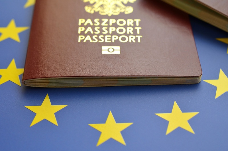 Fragment polskiego paszportu na tle flagi Unii Europejskiej