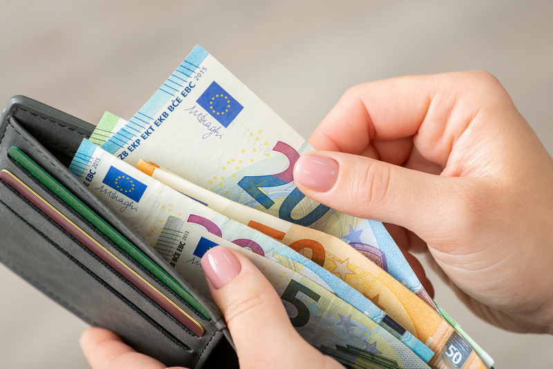 Kobieta przeliczająca banknoty Euro w portfelu