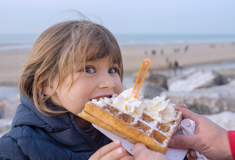 Dziewczynka jedząca gofra na plaży