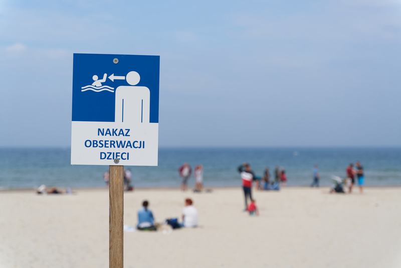 Znak na plaży nad Bałtykiem o nakazie obserwacji dzieci