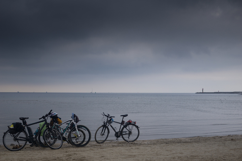 Ciemne chmury nad Bałtykiem i rowery stojące na plaży
