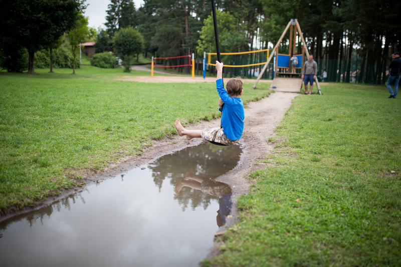 Chłopiec na tyrolce na placu zabaw w lesie