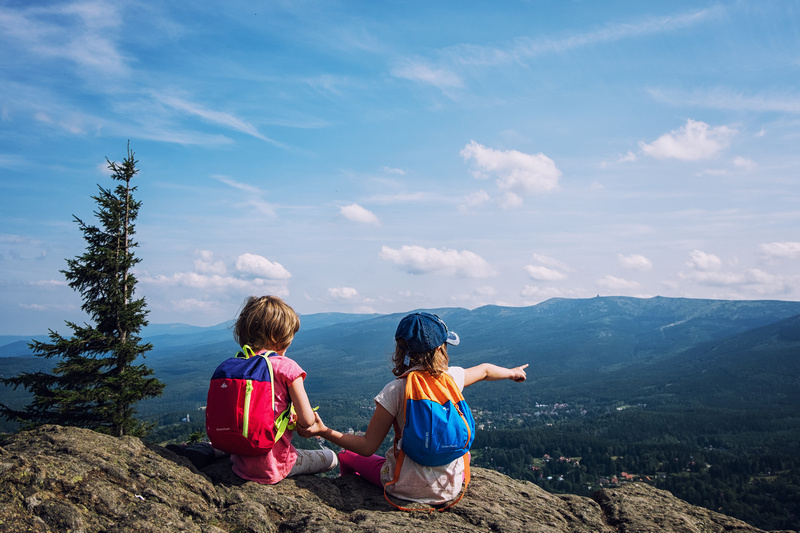 Dwójka dzieci z plecakami w górach
