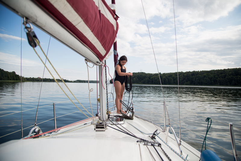 Dziewczynka na dziobie żaglówki na jeziorze