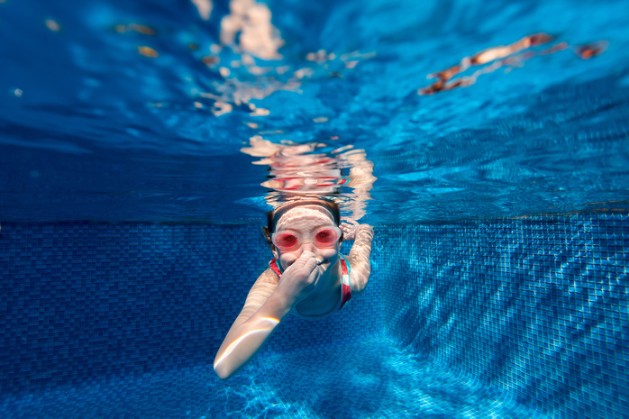 Dziewczynka pływająca w basenie w aquaparku