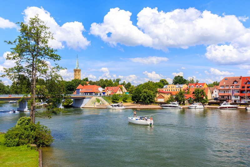 Jacht na jeziorze z Mikołajkami w tle