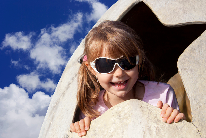 Uśmiechnięta dziewczynka w okularach przeciwsłonecznych