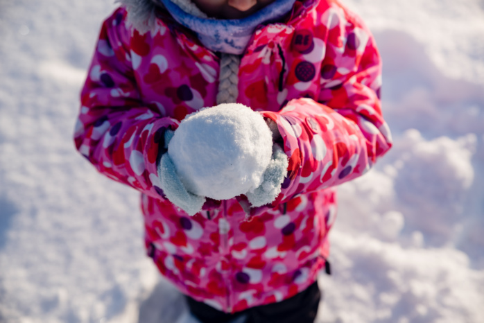 Dziecko formujące kulę ze śniegu