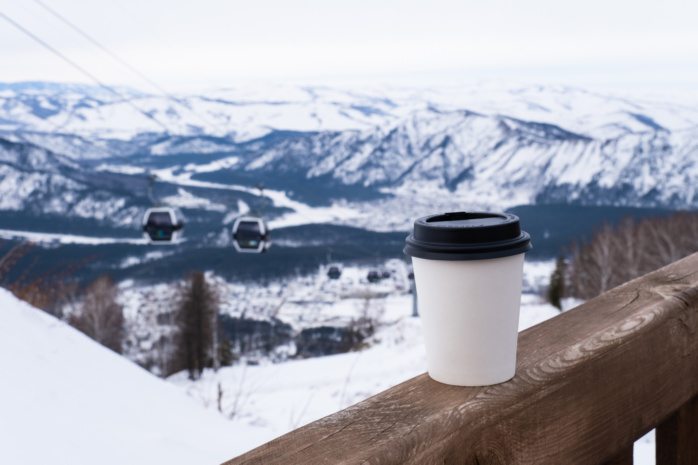 Kubek kawy na tle wyciągu narciarskiego