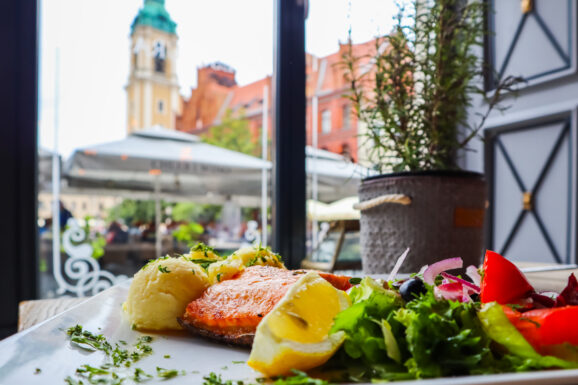 Posiłek w restauracji z widokiem na zabytkowe zabudowania Torunia