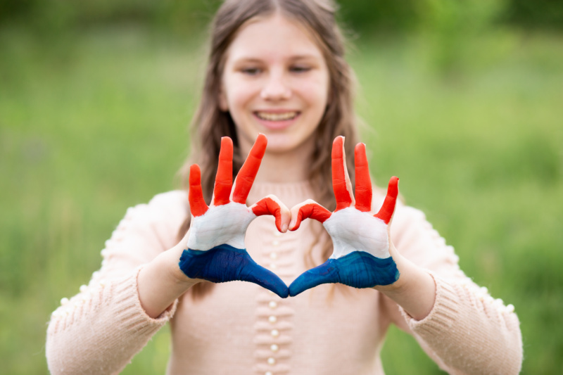Dziewczynka z dłońmi ułożonymi w serce i pomalowanymi kolorami flagi Chorwacji