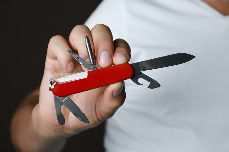 Mężczyzna prezentujący czerwone narzędzie multitool