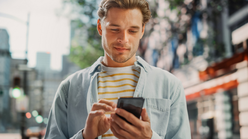 Mężczyzna w mieście patrzący w telefon