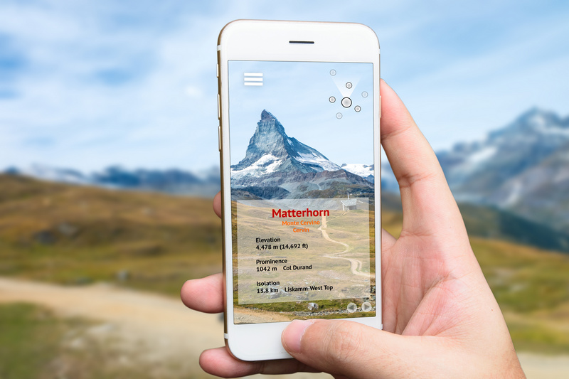 Ręka z telefonem z aplikacją do sprawdzania szczytów górskich z widokiem Matterhornu
