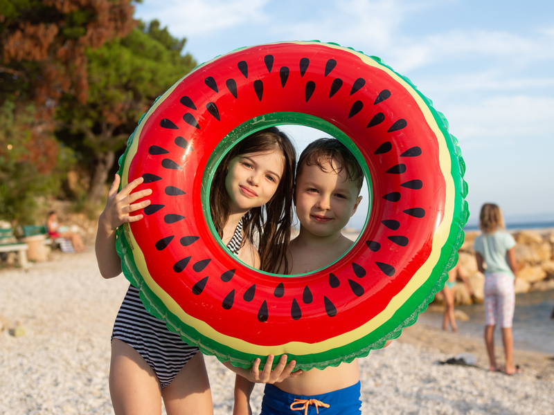Dwoje dzieci z kółkiem do pływania na plaży w Dalmacji