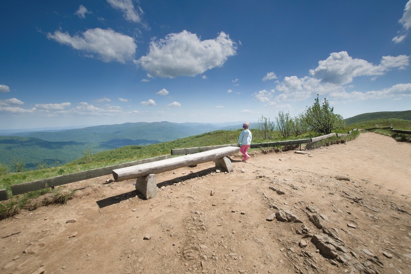 Mała dziewczynka oglądająca panoramę gór ze szczytu
