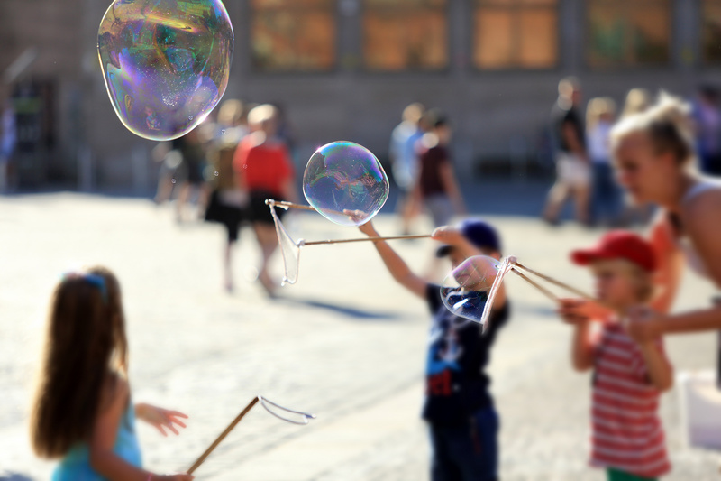 Dzieci na wrocławskim rynku puszczające ogromne bańki mydlane