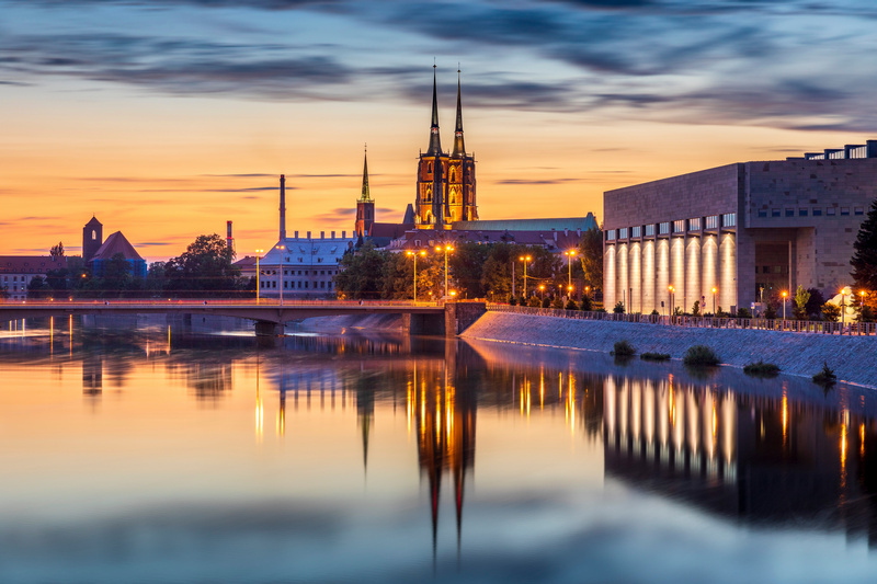 Wrocławska katedra i Biblioteka Uniwersytecka odbijające się w Odrze o zachodzie słońca