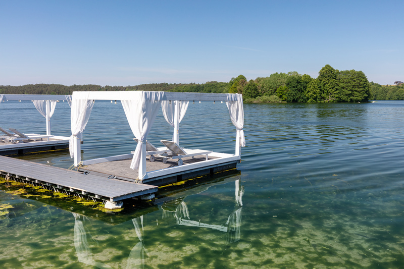 Pomost nad jeziorem z baldachimem i łóżkami do opalania