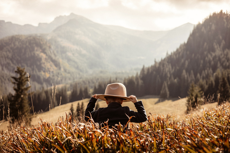 Chłopiec w kapeluszu z panoramą gór w tle