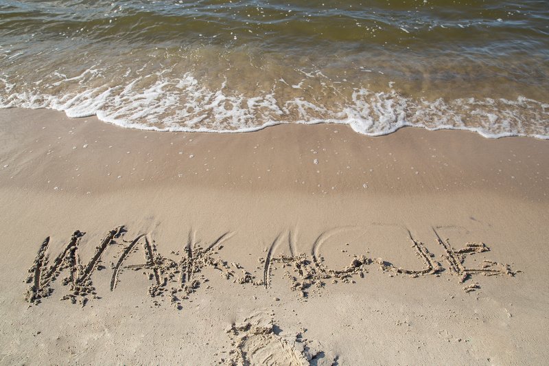 Napis wakacje na piasku nad morzem