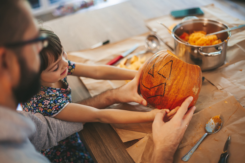 Tata z córka wycinający dynię na Halloween