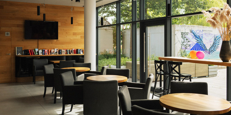 Lobby bar z biblioteczką i grami planszowymi w aparthotelu w Mielnie