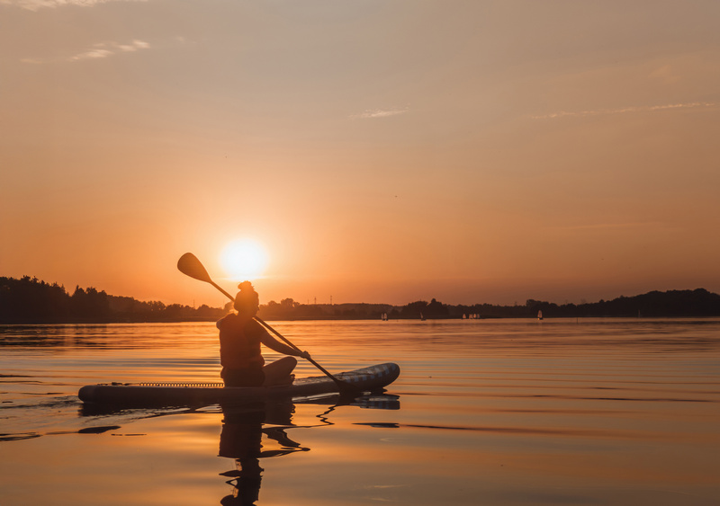 Kobieta pływająca na SUPIE po Jeziorze Kierskim o zachodzie słońca
