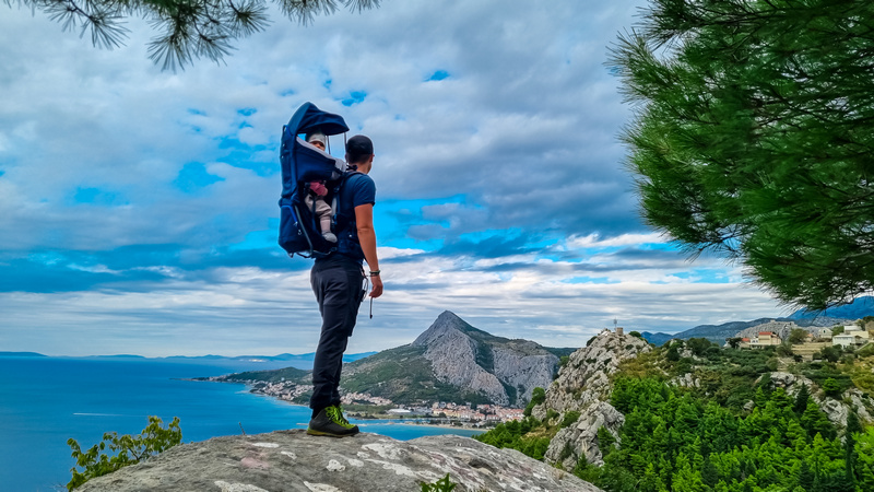 Mężczyzna z dzieckiem w nosidle na plecach w górach Dinara w Chorwacji