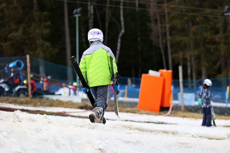 Chłopiec idący po stoku zjazdowym dla nart