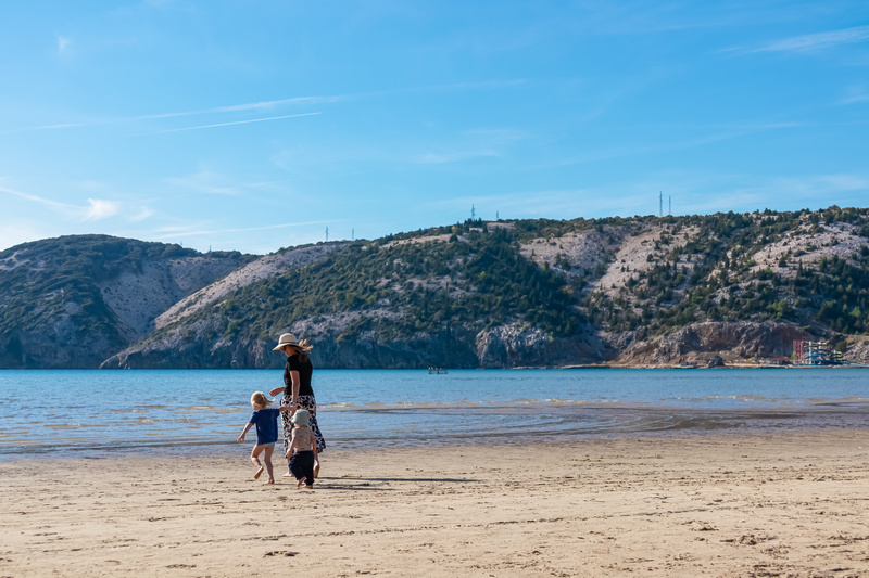 Mama z dziećmi spacerująca na plaży w Chorwacji