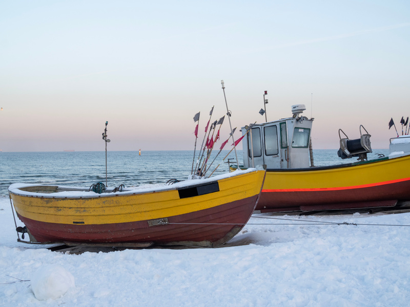 Ośnieżone kutry rybackie na plaży