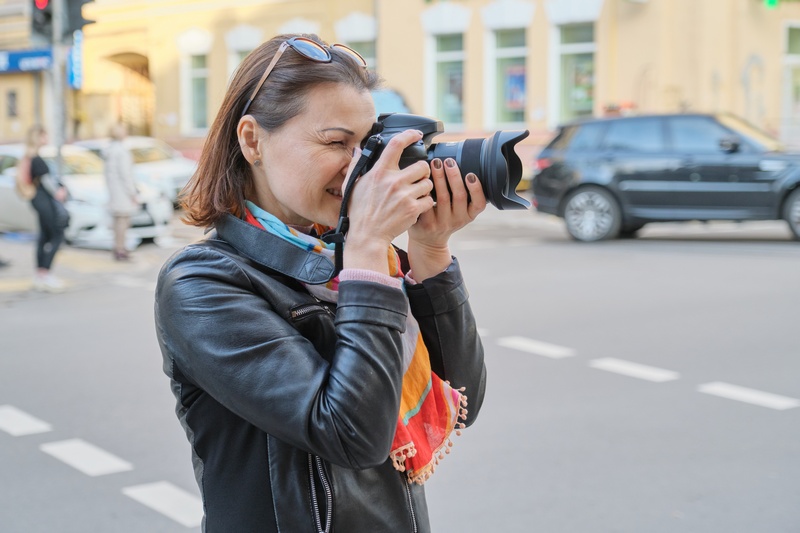 Kobieta na ulicy robiąca zdjęcie lustrzanką