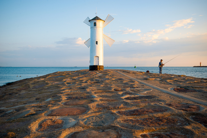 Mężczyzna łowiący ryby pod Stawa Młyny o zachodzie słońca