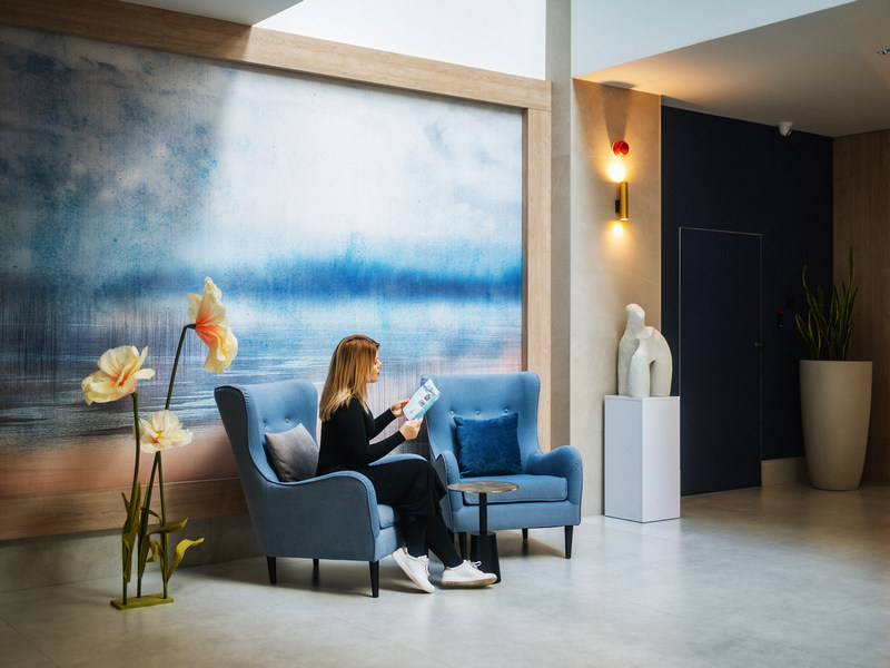 Kobieta siedząca na fotelu w hotelowym lobby