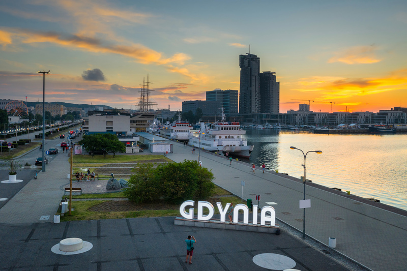 Widok miasta z napisem Gdynia po zachodzie słońca