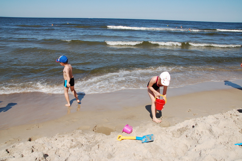 Dzieci bawiące się na plaży nad brzegiem morza
