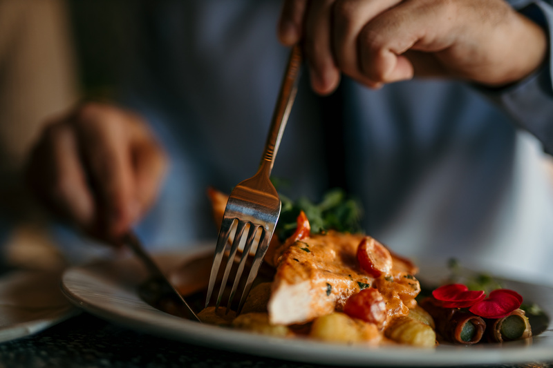 Zbliżenie na dłonie i potrawę w restauracji