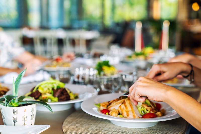 Zbliżenie na dłonie osób jedzących posiłek w restauracji