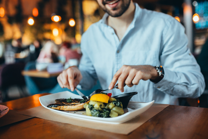 Zbliżenie na mężczyznę jedzącego rybę w restauracji