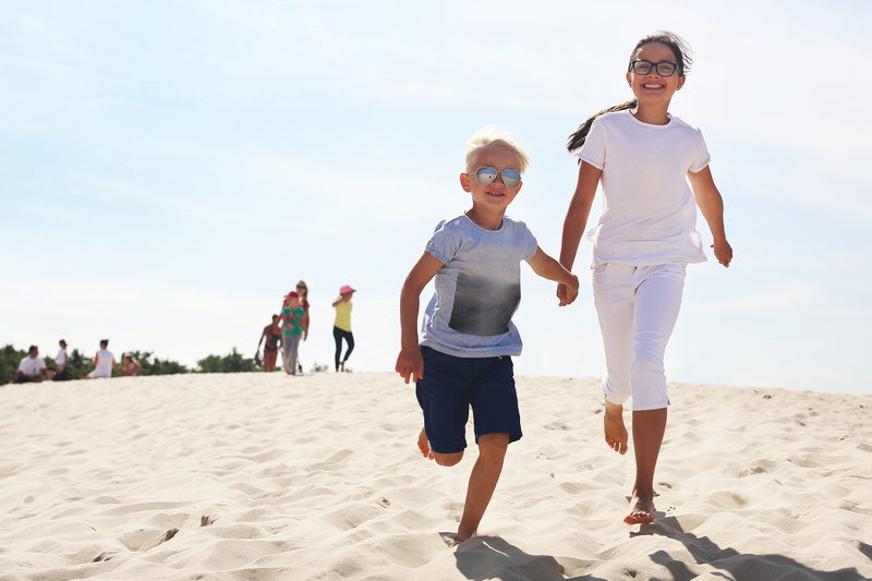 Dzieci biegające po piaszczystej plaży