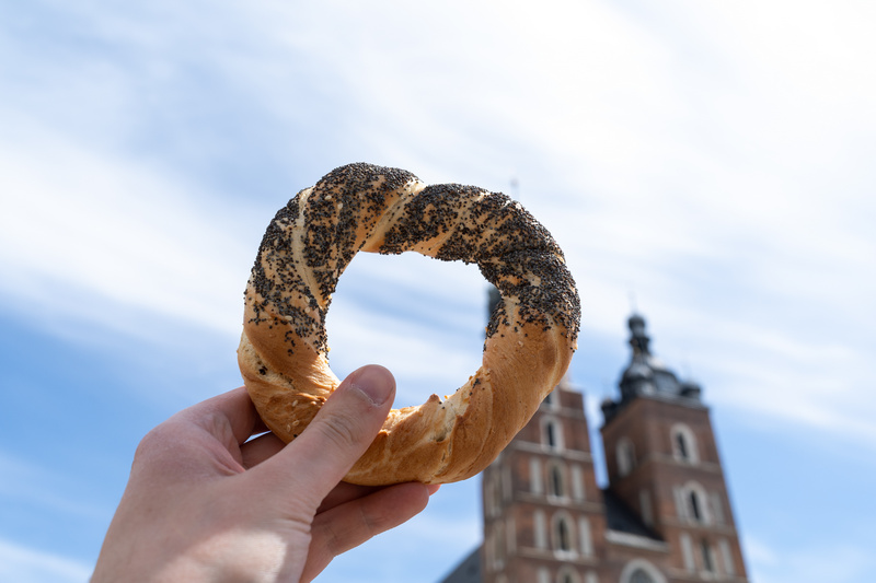 Dłoń trzymająca obwarzanka na tle Bazyliki Mariackiej