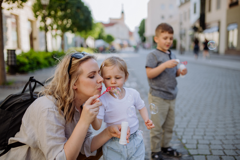 Mama puszczająca z dziećmi bańki mydlane