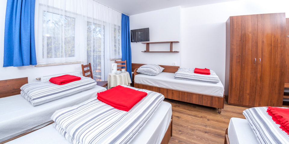 Pokoje 4-osobowe posiadają osobne pojedyncze łóżka, czajnik, TV, sprzęt plażowy