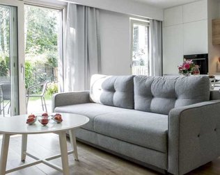 4-osobowy apartament Rubin z sofą w salonie i wyjściem na taras