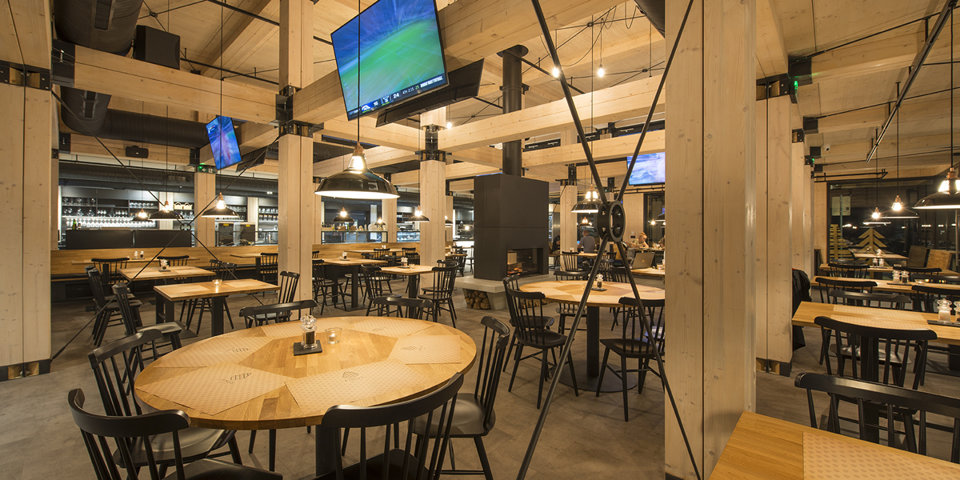 Restauracja jest wykończona w drewnie, posiada kominek i duże ekrany