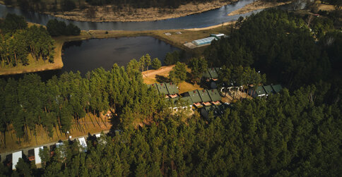 Kompleks domków jest malowniczo położony pośród lasu, nad Wartą i jeziorem
