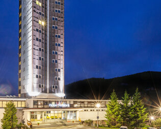 Hotel ma kształt wysokiej wieży, dzięki czemu pokoje oferują widoki na góry